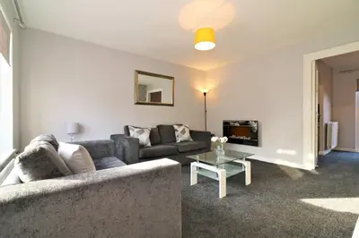 a living room with a couch and a table at Signature - Chapelhall House in Chapelhall