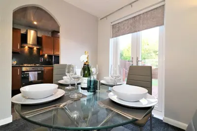 a dining room with a glass table with chairs at Signature - Chapelhall House in Chapelhall