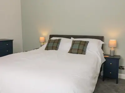 a bedroom with a white bed with two night stands at 40 Main Street in Burntisland