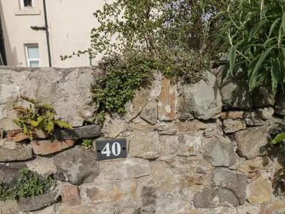 a stone wall with a sign on it at 40 Main Street in Burntisland