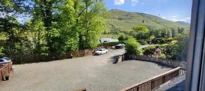 a view of a driveway with a car parked on the road at Ben Reoch Cottage - Loch Lomond and Arrochar Alps in Tarbet