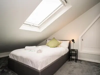 a bedroom with a large bed with a skylight at 2BD Loft Style Apt - Edinburgh - Free Parking - Pass the Keys in Edinburgh