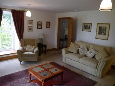 a living room with a couch and a chair at Old Coach House in Moniaive