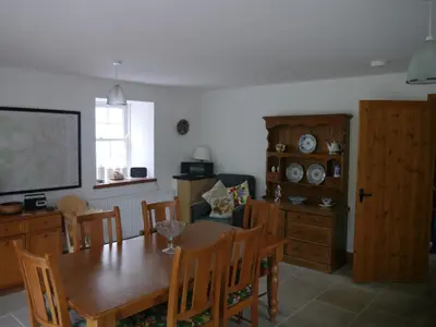 a dining room with a wooden table and chairs at Old Coach House in Moniaive