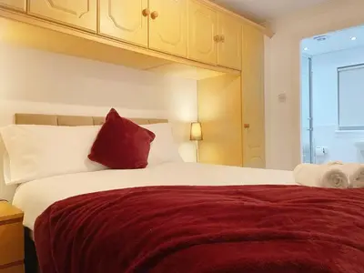 a bedroom with a large white bed with red pillows at Cozy Nights SVP Detached House in Nitshill