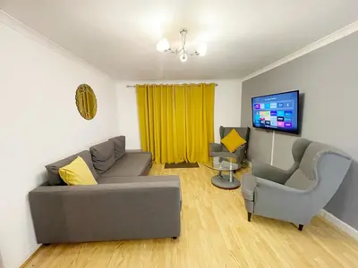 a living room with a couch and two chairs and a tv at Cozy Nights SVP Detached House in Nitshill
