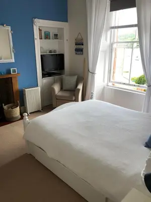 a bedroom with a large white bed and a window at Tighnabruaich Duplex Apartment - Sea Views in Tighnabruaich