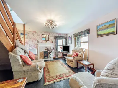a living room with two chairs and a television at The Stables - Uk37415 in Bunessan