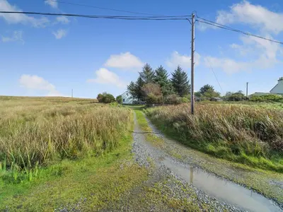 a dirt road in the middle of a field at The Stables - Uk37415 in Bunessan