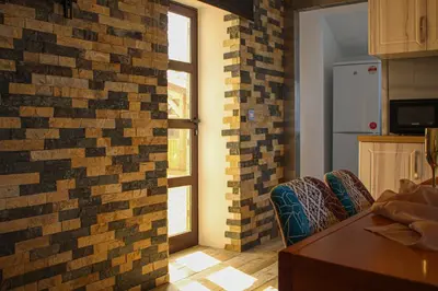 a kitchen with a brick wall and two windows at Deluxe Apartment in Lanark