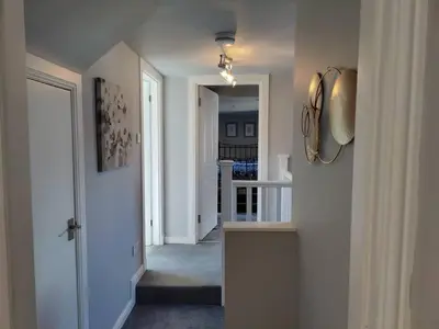 a hallway of a home with a door and a staircase at Fabulous 2BD Maisonette Dunfermline, Fife in Dunfermline