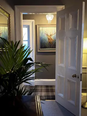 a hallway with a door and a plant in a room at Glencruitten House in Oban