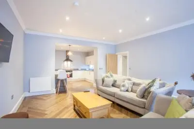 a living room with a couch and a table at Stylish 2 Bedroom Apartment In Park Circus, West End in Glasgow