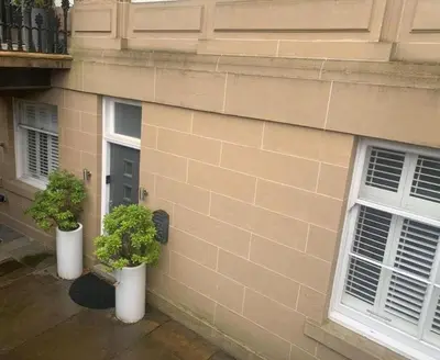 two plants in white pots on the side of a building at Stylish 2 Bedroom Apartment In Park Circus, West End in Glasgow