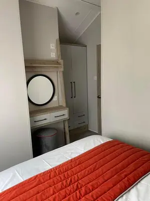 a bedroom with a bed with a mirror and a dresser at The Astoria 41 in Dunoon