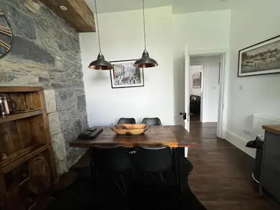 a dining room with a wooden table and chairs at The Lowry .. Where elegance meets Luxury! in Oban