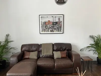 a brown leather couch in a living room with a picture at The Lowry .. Where elegance meets Luxury! in Oban