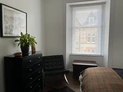 a bedroom with a dresser and a chair and a window at The Lowry .. Where elegance meets Luxury! in Oban