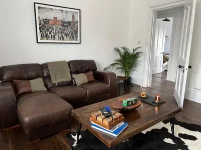 a living room with a brown couch and a coffee table at The Lowry .. Where elegance meets Luxury! in Oban