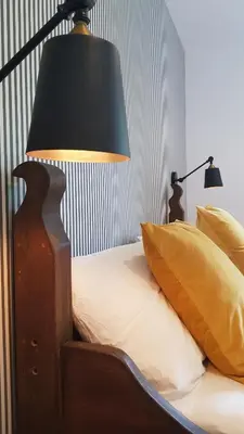a bedroom with a bed with a lamp and pillows at Ronachan in Clachan