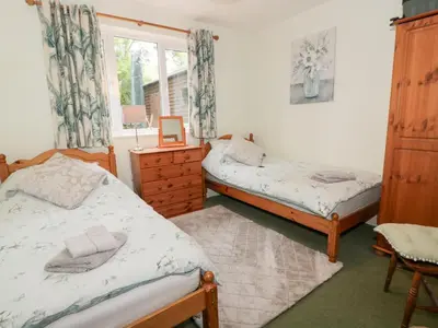 a bedroom with two beds and a window at Strathannan in Moffat