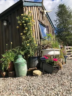 a garden with a bath tub and some plants at The Loveshack Lodge Balquhidder in Balquhidder