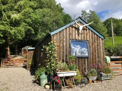 a small shed with a tv on the side of it at The Loveshack Lodge Balquhidder in Balquhidder