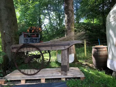 a cart sitting on a wooden table in the grass at The Loveshack Lodge Balquhidder in Balquhidder