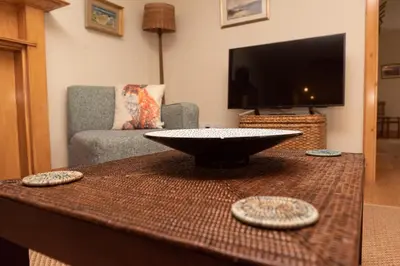 a living room with a table with a bowl on it at Steading Cottage - 50m from the beach in Port Appin