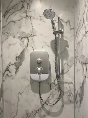 a shower in a bathroom with a marble wall at White Cottage - Cosy Holiday Cottage in Drymen, Loch Lomond & Trossachs in Drymen
