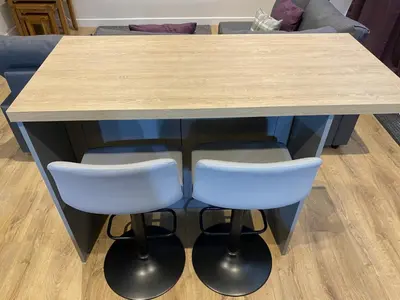 a wooden table with two white stools under it at White Cottage - Cosy Holiday Cottage in Drymen, Loch Lomond & Trossachs in Drymen