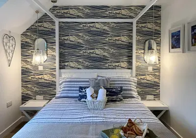a bedroom with a blue bed with a wall at Coorie Doon in Cairnbaan