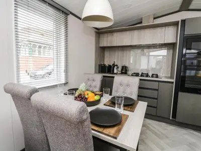 a kitchen with a table with a bowl of fruit on it at Red Kite Lodge in Crieff