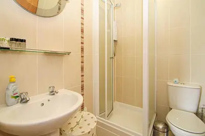 a bathroom with a sink and a toilet and a shower at Tinto View Apartment in Carstairs
