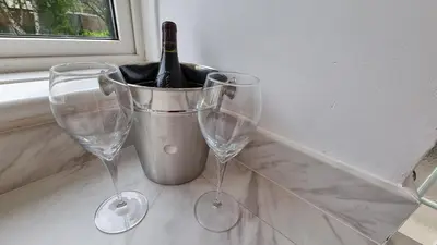 two wine glasses and a bucket with a bottle of wine at Rozelle Villa in Ayr