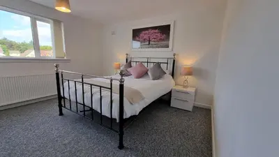 a bedroom with a bed and a window at Rozelle Villa in Ayr