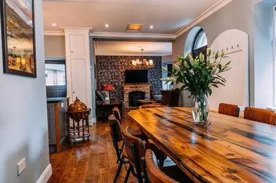 a dining room with a wooden table with a vase of flowers at Stylish Loch Lomond lodge in stunning surroundings in Balloch