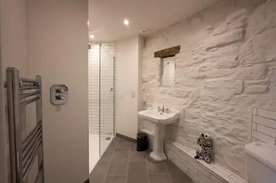 a white bathroom with a sink and a shower at Laverockbank Steading in Buchanty