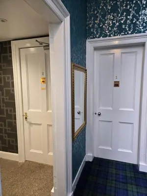 a hallway with a white door and a mirror at IVY House in Edinburgh