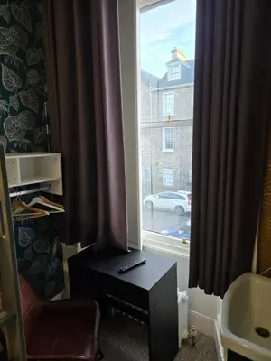 a room with a window with curtains and a chair at IVY House in Edinburgh