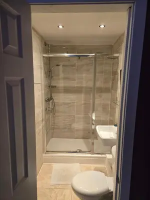 a bathroom with a shower and a toilet and a sink at IVY House in Edinburgh