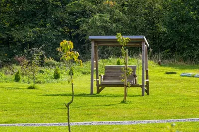 a park bench sitting in a field of grass at Fulshaw Mill Holidays in Stewarton