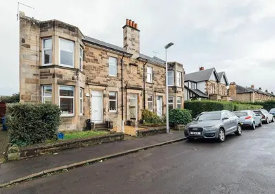 a car parked in front of a row of houses at The Riverside Apartment (free parking) in Stirling