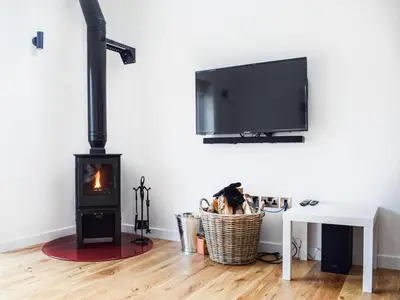 a living room with a wood stove and a tv at Rubys Cottage in Crieff