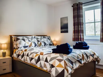 a bedroom with a bed with blue towels on it at Rubys Cottage in Crieff