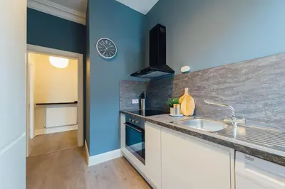a kitchen with a sink and a blue wall at Stylish Stirling Apartment - free parking in Stirling