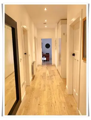 an empty hallway with a hard wood floor in a house at Spacious and modern 2 bedroom flat near the City Centre in Edinburgh