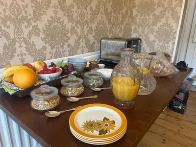 a table with a bowl of fruit and a bottle of orange juice at Callander Meadows in Callander