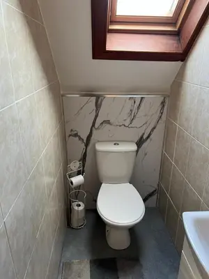 a small bathroom with a toilet and a sink at 4 bed bungalow near Airport in Edinburgh