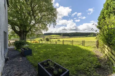 a garden with twopots of plants in a field at Wilsons Cottage in Falkirk